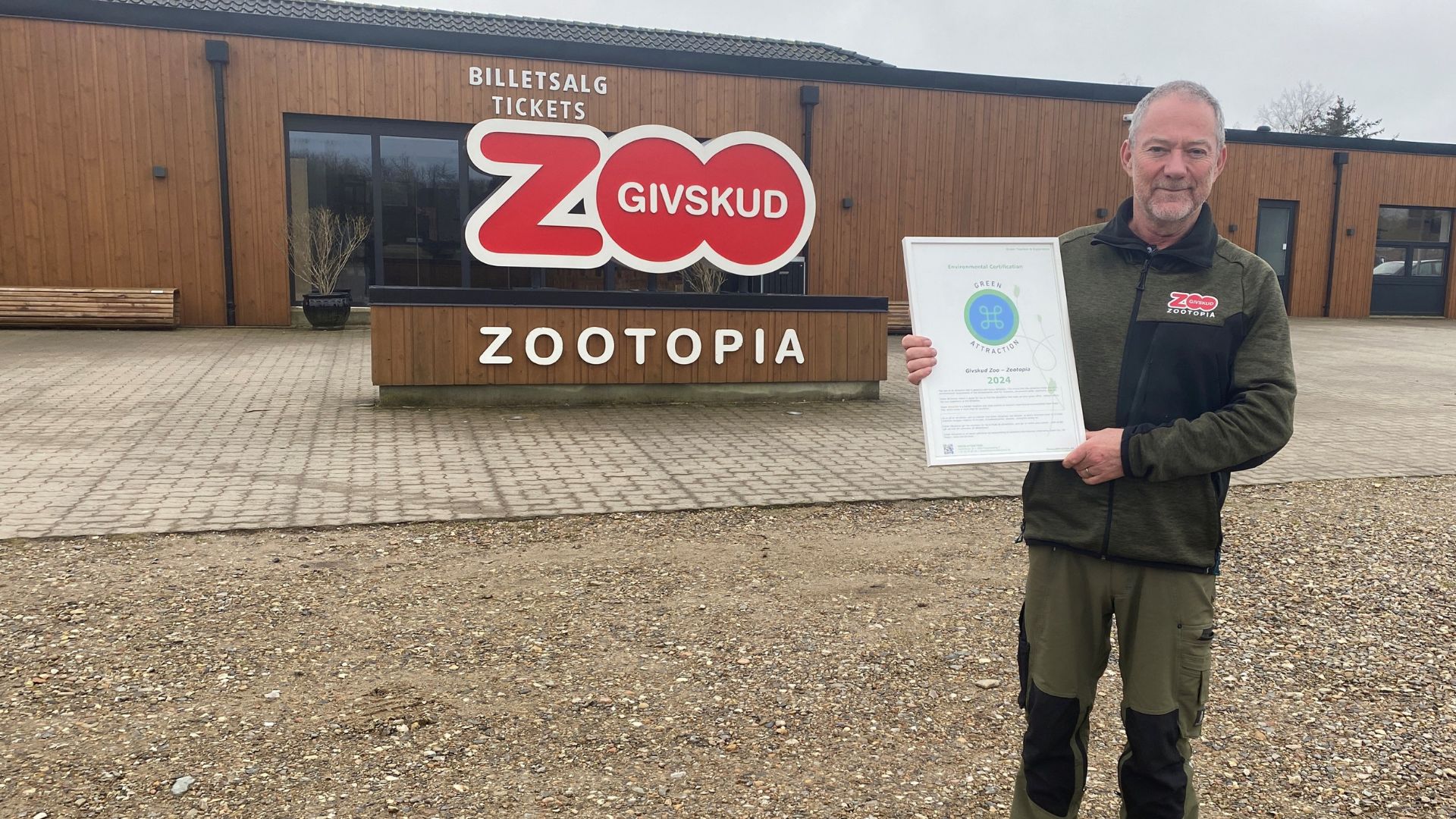 Direktør Richard Østerballe med det synlige bevis på, at Givskud Zoo nu må kalde sig Green Attraction. (PR-foto)
